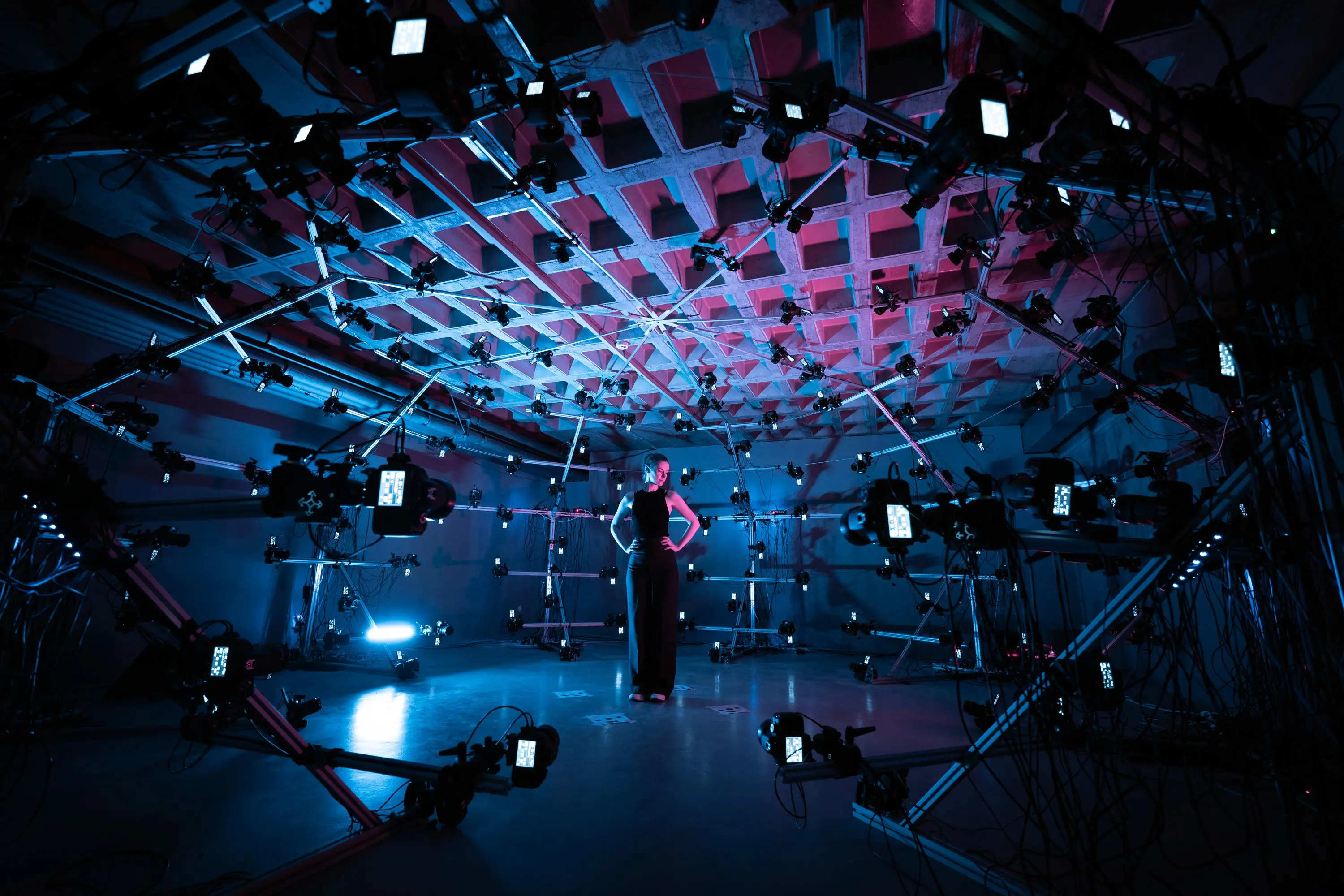 A model stands inside the 151-camera scanner, lit in blue.